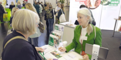 Eine Frau spricht mit einer interessierten Frau an einem Stand.