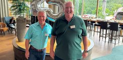 Zwei Männer posieren auf einer Feier für ein Foto.