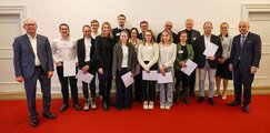 Gymnasium Oberhaching Schülerinnen und Schüler stehen gemeinsam mit ihren Lehrkräften auf einem roten Teppich und halten Urkunden in der Hand.