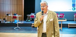 Michael Mötter, stellvertretender Geschäftsführer des bbw e. V. Ein Mann hält ein Mikrofon in der Hand und spricht zu Publikum.