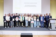 Eine Gruppe Schüler steht auf einer Bühne und erhält einen Preis.