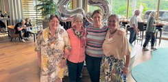 Vier Frauen posieren auf einer Feier für ein Foto.
