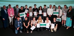 Eine Gruppe von Schülern posiert mit Urkunden in der Hand gemeinsam mit mehreren Erwachsenen für ein Foto.