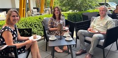 Jubilar*innen feiern 25-jährige Betriebszugehörigkeit Zwei Frauen und ein Mann sitzen bei Kaffee und Kuchen zusammen und lächeln in die Kamera.