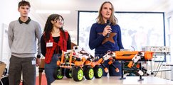Drei Schüler*innen präsentieren ihren selbstgebauten Roboter.