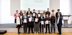 Illertal-Gymnasium Vöhringen Auf der Bühne steht eine Schulklasse, welche in die Kamera lächelt. Die Jugendlichen halten Urkunden und einen Preis in der Hand.