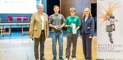 Die Staatlichen Realschule Schonungen mit dem Team "Die zwei Rabauken" Zwei Jugendliche, ein Mann und eine Frau posieren samt Auszeichnung für ein Foto.