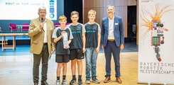 Das Siegerteam der Johann-Simon-Mayer-Schule Riedenburg Drei Jugendliche posieren mit Auszeichnung in der Hand mit zwei Männern für ein Foto.