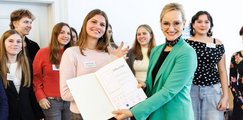 Sandra Stenger, bbw-Vorstandsvorsitzende, überreicht den Schüler*innen des Albert-Einstein-Gymnasiums in München die Urkunde zum P-Seminar-Preis.