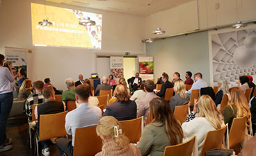 Vielseitiges Programm Eine Publikum hört einer Podiumsdiskussion zu.