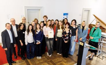 Eine Gruppe Schüler*innen aus München posiert mit mehreren Erwachsenen für ein Foto bei der Preisverleihung.