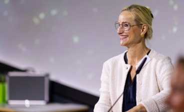 bbw-Vorstandsvorsitzende Sandra Stenger steht an einem Pult und blickt lächelnd ins Publikum.