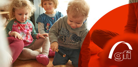 Drei Kindergartenkinder spielen miteinander.