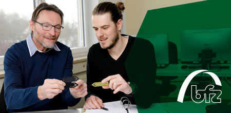 bfz Ausbildungssuche und -vorbereitung Ein Mann und ein Auszubildender sitzen nebeneinander und besprechen Schulstoff.