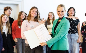 Sandra Stenger, bbw-Vorstandsvorsitzende, überreicht den Schüler*innen des Albert-Einstein-Gymnasiums in München die Urkunde zum P-Seminar-Preis.