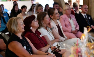 Mehrere Personen, vorwiegend Frauen, sitzen im Publikum der Jubiläumsfeier.
