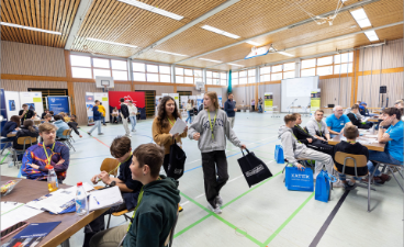 Jugendliche in verschiedenen Workshops in einer großen Halle