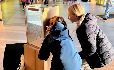 Zwei Kinder schauen in eine Spiegelbox