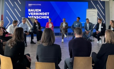 Mehrere Menschen sitzen in einem Stuhlkreis und tauschen sich aus.