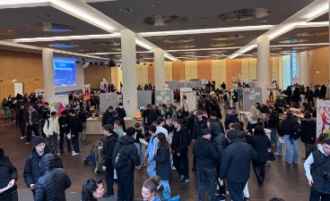 Viele wuselnde Menschen in einem großen Saal